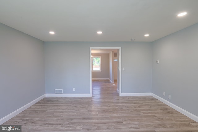 empty room with baseboards, light wood finished floors, recessed lighting, and visible vents