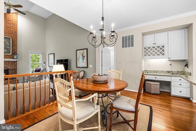 9 Selsed Garth, Lutherville Timonium, MD 21093 - dining area with visible vents, a brick fireplace, built in desk, ceiling fan with notable chandelier, and light wood-style flooring