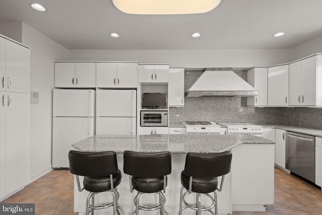 23 Deerfield Rd, Lancaster, PA 17603 - kitchen with white cabinets, custom range hood, a center island, a kitchen bar, and white appliances