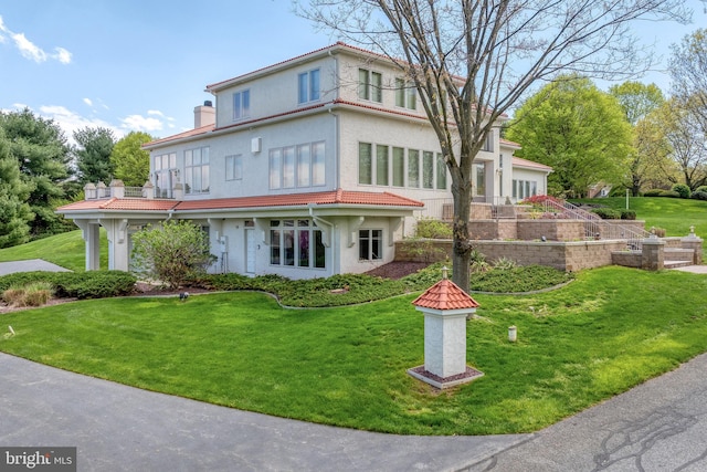 23 Deerfield Rd, Lancaster, PA 17603 - rear view of house with a tile roof, a balcony, a lawn, a chimney, and stucco siding
