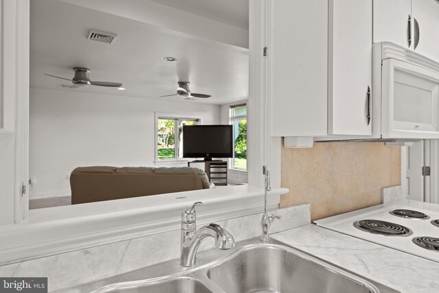 23 Deerfield Rd, Lancaster, PA 17603 - kitchen with white microwave, light countertops, white cabinetry, visible vents, and a ceiling fan