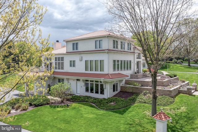 23 Deerfield Rd, Lancaster, PA 17603 - back of property with a tile roof, a lawn, stucco siding, and a chimney