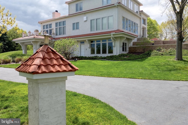 23 Deerfield Rd, Lancaster, PA 17603 - exterior space featuring a tile roof, a front lawn, stucco siding, and a chimney