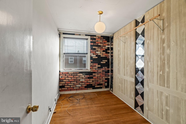 unfurnished room with baseboards and wood finished floors