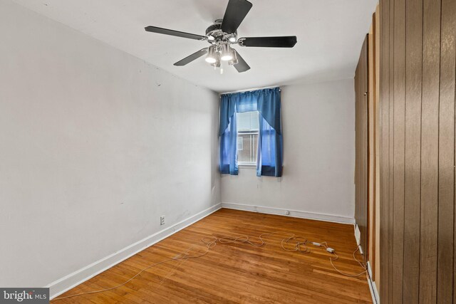 unfurnished room featuring baseboards, ceiling fan, and wood finished floors