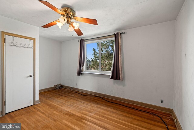 unfurnished bedroom featuring a ceiling fan, baseboards, and light wood-style floors