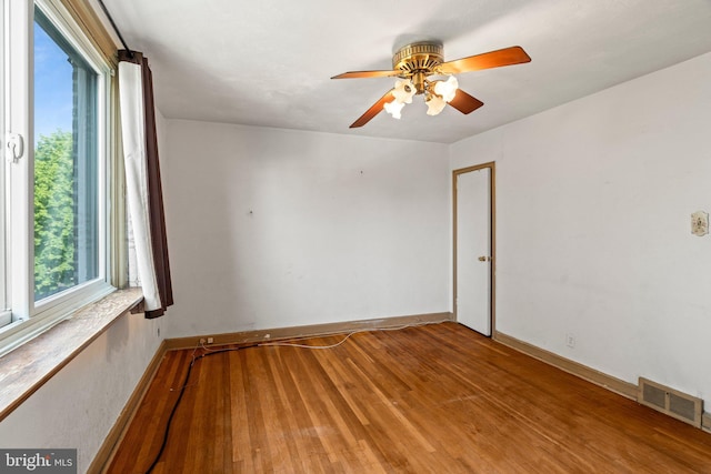 unfurnished room featuring light wood-style floors, baseboards, a ceiling fan, and visible vents
