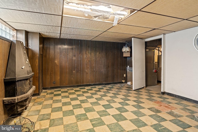 below grade area featuring light floors, baseboards, and wood walls