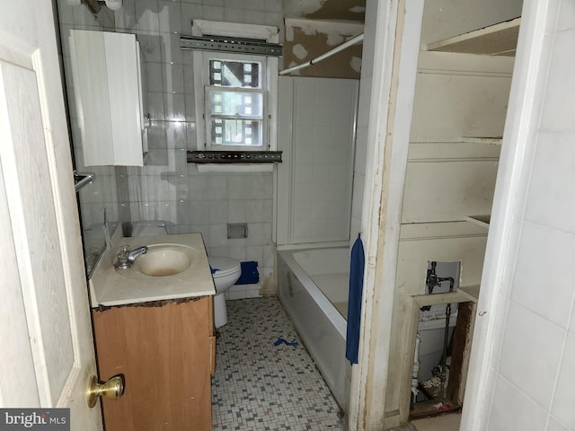 130 5th Ave, Baltimore, MD 21227 - full bathroom featuring vanity, toilet, tile patterned floors, tile walls, and  shower combination