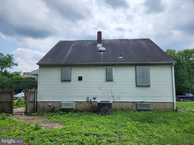 130 5th Ave, Baltimore, MD 21227 - rear view of house featuring crawl space, a chimney, and central AC unit