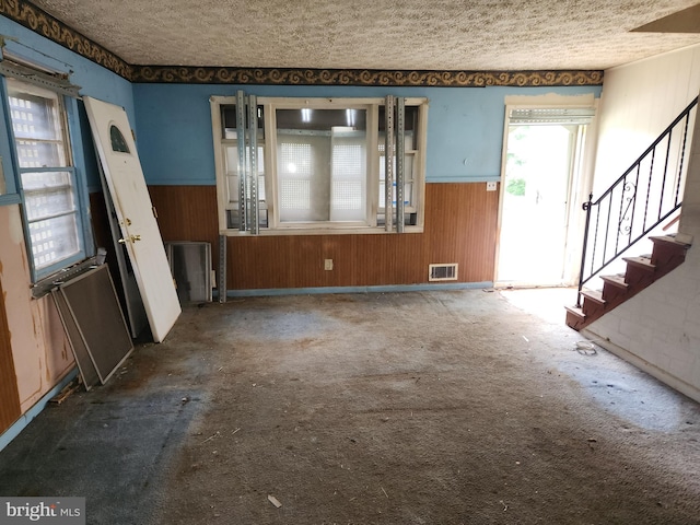 130 5th Ave, Baltimore, MD 21227 - entrance foyer with wainscoting, wooden walls, stairs, a textured ceiling, and carpet flooring