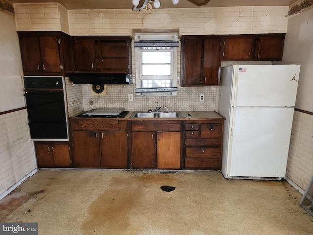 130 5th Ave, Baltimore, MD 21227 - kitchen featuring freestanding refrigerator, a sink, tasteful backsplash, dark brown cabinetry, and dark countertops