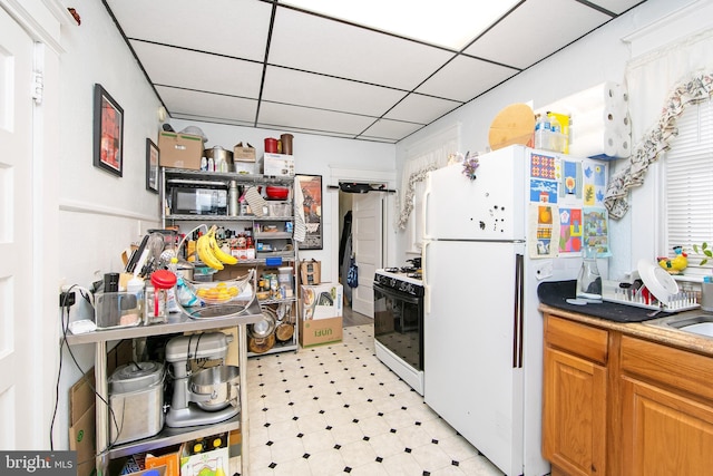 1104 High St, Haddon Heights, NJ 08035 - kitchen with freestanding refrigerator, range with gas cooktop, light floors, and a drop ceiling