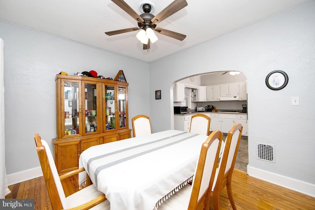 1104 High St, Haddon Heights, NJ 08035 - dining room with a ceiling fan, arched walkways, light wood finished floors, and baseboards