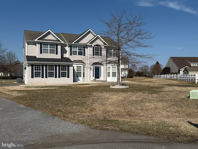 view of front of property featuring fence and a front lawn