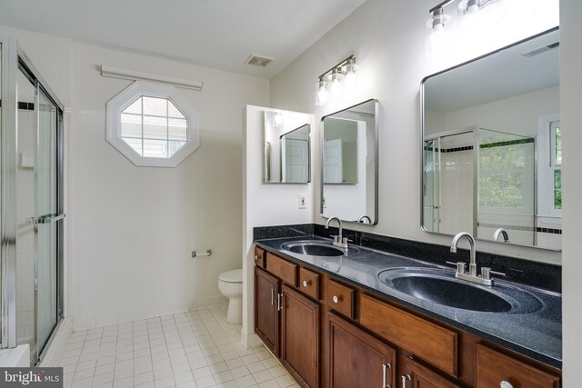 6732 Baron Rd, Mclean, VA 22101 - full bathroom with double vanity, toilet, a stall shower, and tile patterned floors