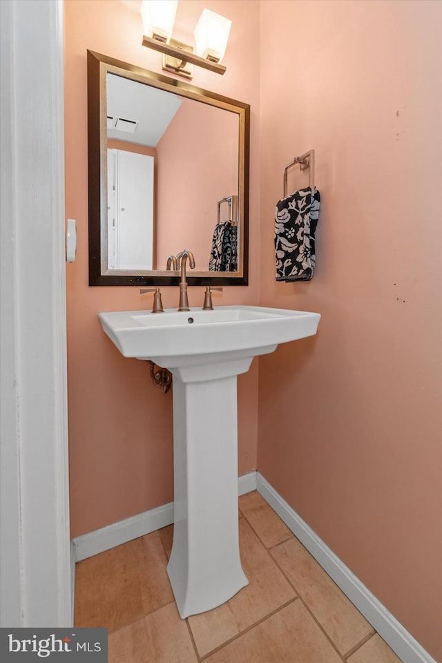 bathroom with tile patterned flooring, a sink, visible vents, and baseboards