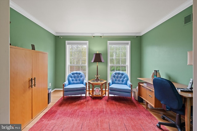 home office featuring wood finished floors, visible vents, and ornamental molding