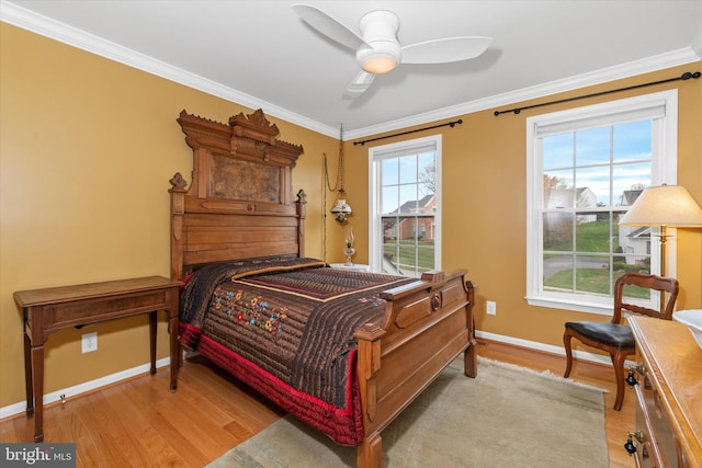 bedroom featuring baseboards, wood finished floors, a ceiling fan, and crown molding