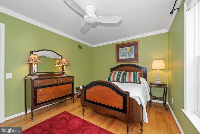 bedroom with visible vents, ceiling fan, baseboards, ornamental molding, and wood finished floors
