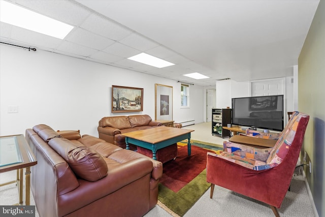carpeted living room featuring a drop ceiling and baseboard heating