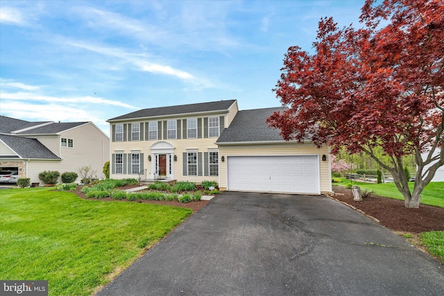 colonial home with a front yard, driveway, and an attached garage