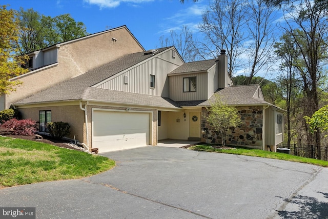 townhome / multi-family property featuring fence, roof with shingles, a chimney, an attached garage, and driveway