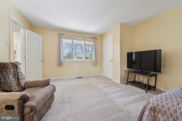 carpeted living area featuring baseboards and visible vents
