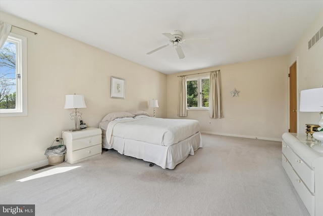 bedroom with baseboards, visible vents, light carpet, and ceiling fan