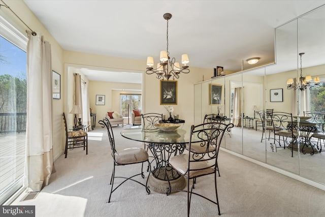 dining area with carpet floors, plenty of natural light, and a notable chandelier
