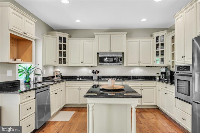 kitchen featuring a kitchen island, light wood-type flooring, recessed lighting, a sink, and stainless steel appliances