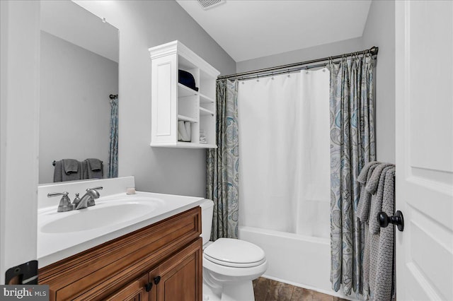 bathroom with vanity, shower / bath combo, toilet, and visible vents