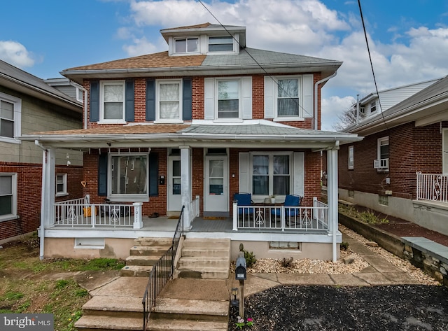 view of front of property with a porch, brick siding, cooling unit, and roof with shingles