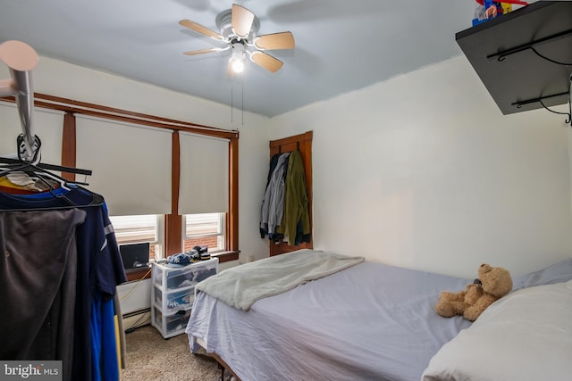 carpeted bedroom featuring a ceiling fan and a baseboard heating unit