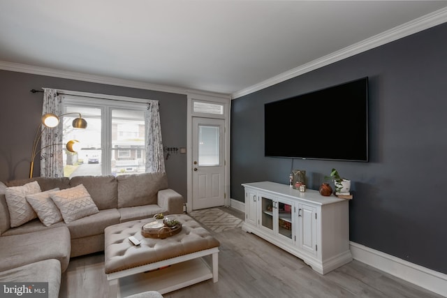 living area featuring baseboards, light wood finished floors, and crown molding