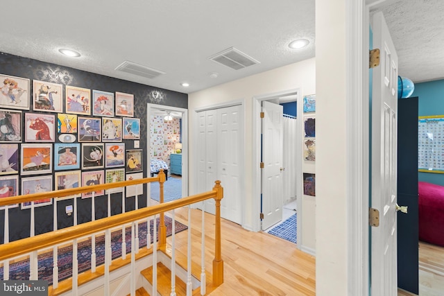 260 High Banks Rd, Stephenson, VA 22656 - corridor with an upstairs landing, visible vents, wood finished floors, and a textured ceiling