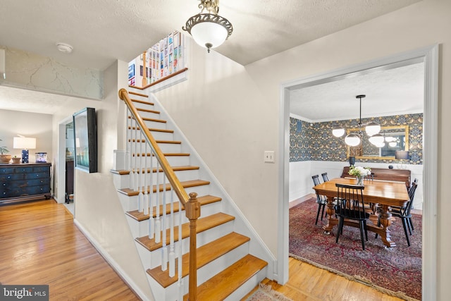 260 High Banks Rd, Stephenson, VA 22656 - staircase featuring wood finished floors, a notable chandelier, and a textured ceiling