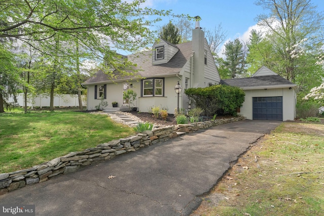 cape cod-style house with a front lawn, aphalt driveway, a chimney, roof with shingles, and fence
