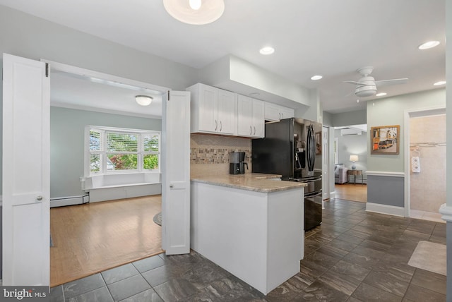 kitchen with white cabinetry, tasteful backsplash, black fridge with ice dispenser, ceiling fan, and baseboard heating