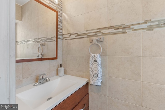 bathroom featuring vanity and tile walls