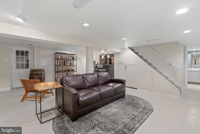 living room featuring baseboards, recessed lighting, stairs, and a dry bar