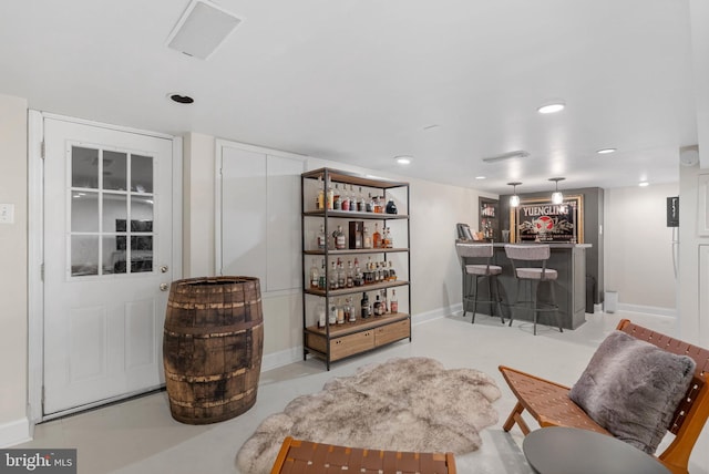 living room featuring recessed lighting, bar area, and baseboards
