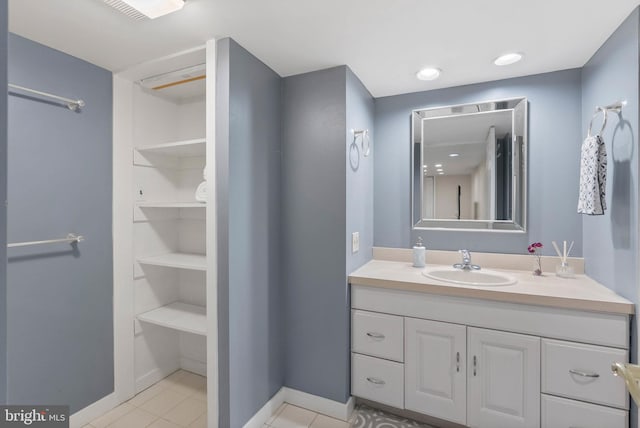 bathroom featuring baseboards, visible vents, tile patterned floors, and vanity