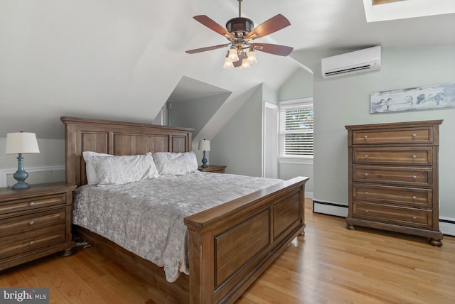 bedroom with vaulted ceiling with skylight, a wall unit AC, ceiling fan, light wood-style flooring, and a baseboard radiator