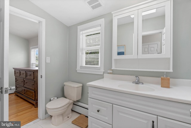 bathroom featuring vanity, toilet, visible vents, tile patterned flooring, and baseboard heating