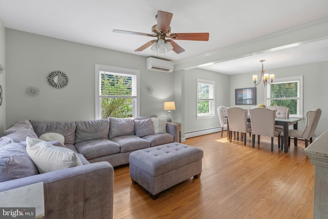 living area with light wood-style flooring, baseboard heating, a wall mounted AC, and ceiling fan with notable chandelier