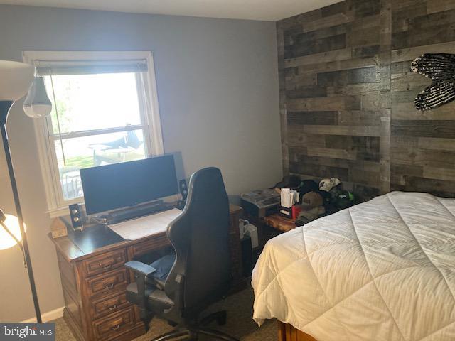 carpeted bedroom featuring baseboards and multiple windows
