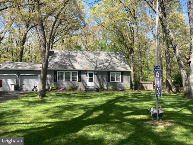 single story home with an attached garage, driveway, and a front yard