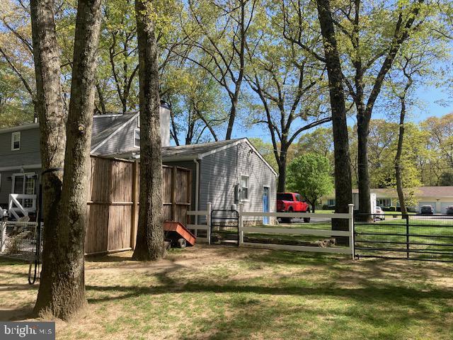 view of home's exterior with a gate, fence, and a yard