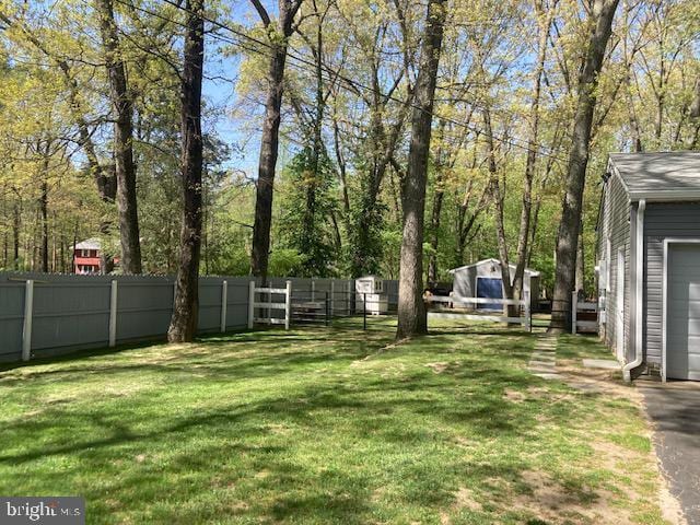 view of yard with an outdoor structure, a garage, and fence